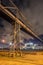 Night scene with illuminated petrochemical production plant and pipeline overpass,