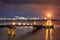 night scene with Illuminated pier with ponton in a river and large petrochemical industry