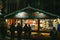 Night scene with row of market stalls chalets with multiple toys and souvenirs for sale in Place de la Cathedrale Notre