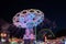 Night scenery atmosphere with colourful illumination motion of carousel in amusement park.