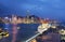 Night scenery of Hong Kong with a skyline of crowded skyscrapers by Victoria Harbor, a luxury cruise liner parking by the pier