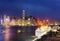 Night scenery of Hong Kong with a skyline of crowded skyscrapers by Victoria Harbor, a luxury cruise liner parking by the pier 