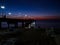 night sea landscape. the pier is lit by lanterns. Silhouettes of beach