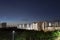 Night shot of condominium with moon, blue sky and night lights. landscape slow shutter shot of residential condos with car trails