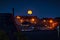 Night shot of the house buildings of the village of Queensbury and the full moon
