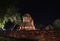 Night shot of incomplete small stupa beside the wall in the ruins of ancient remains.