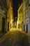 Night shot of a narrow lonely alley illuminated and with the shadow of the photographer