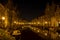 A night shot from the old bridge The Kerkbrug on the Oude Rijn with numerous boats and illuminated old canal-side houses, Leiden