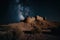 night sky above historic desert fort, with stars shining bright and moon visible