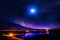 night sky on sea big moon on horizon mountains mediterranean sunset blurred city light