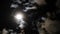Night sky with shining full moon behind moving dramatic clouds. Time lapse