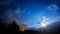 Night sky stars, moon and clouds across mountain