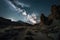 night sky, with stars and moon shining above desert canyon, surrounded by towering rock formations