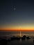 Night sky stars Pleiades Venus and Moon set observing over sea coast
