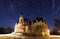 Night sky with stars trail and ancient castle