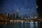 Night skyline of illuminated Dubai skyscrapers, with lights reflected in the water, UAE