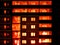 Night snapshot. Dark residential high-rise buildings, in which red light Windows and balconies