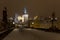 Night snowy colorful Prague Lesser Town with gothic Castle, St. Nicholas` Cathedral from Charles Bridge, Czech republic