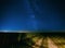 Night Starry Sky Above Country Road In Countryside And Green Field