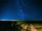 Night Starry Sky Above Country Road In Countryside And Green Field