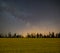 Night starry sky with milky way above a rural rape field