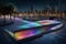 A night-time image of a mosaic podium on a waterfront promenade,