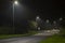 Night time image of suburban street with roundabout and street lights