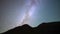 Night time-lapse video of the movement of the milky way over the silhouettes of the mountains. Space video galaxy view