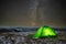 Night at the top of the mountain in a tent in winter against the background of the starry sky