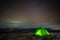 Night at the top of the mountain in a tent in winter against the background of the starry sky