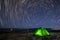 Night at the top of the mountain in a tent in winter against the background of the starry sky