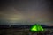 Night at the top of the mountain in a tent in winter against the background of the starry sky