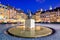 Night view of the bronze statue of Mermaid on the Old Town Market Square of Warsaw, surrounded by colorful old houses.