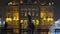 Night view of city life on the cold snowy winter day with buildings and people walking under