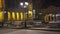 Night view of city life on the cold snowy winter day with buildings and people walking under