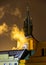 Night view of the clock tower and smoke curling from a chimney in old Prague