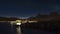 Night view of the coast of AustvÃ¥gÃ¸ya, Lofoten, Norway with traditional stockfish drying racks and illuminated town of SvolvÃ¦r.