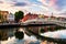 Night view of famous illuminated Ha Penny Bridge in Dublin, Ireland at sunset