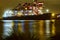 Night view of a gantry working at unloading a bulk carrier.