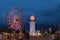 Night view on the illuminated ferris wheel and lighthouse in Batumi, Georgia