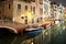Night view of illuminated old architecture, floating boats and light reflections in canals water in Venice, Italy