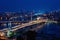 Night view of Istanbul, scenic cityscape with buildings in lights, bridge, bay and blue sky with full moon, Turkey