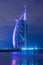 Night view of luxury 7 star hotel Burj Al Arab surrounded with nearest new construction cranes. Shot at blue hours.