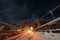 Night view at the metal Ñable-stayed bridge in Swedish countryside illuminated by lights, cold winter blue skies with stars and