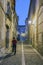 Night view of a narrow cobblestone alley with facades of 16th century houses called Santa Maria next to the Plaza de Cervantes in