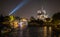 Night view of Notre Dame cathedral with Eiffel Tower searchlight