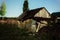 Night view of the old wooden bathhouse, woodpile and fence in the moonlight.