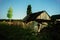 Night view of the old wooden bathhouse, woodpile and fence in the moonlight.