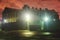 A night view of protected creepy penitentiary prison building facility, asylum exterior with barded wire on walls, red night sky,