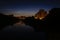 Night view of riverscape with modern blocks of flats partially reflected on the surface of water